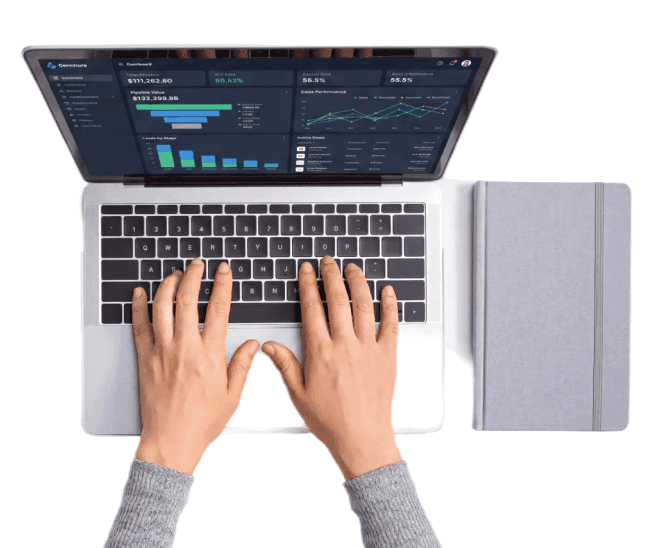 Hands typing on a laptop running a CRM dashboard, surrounded by the apps a business has to juggle