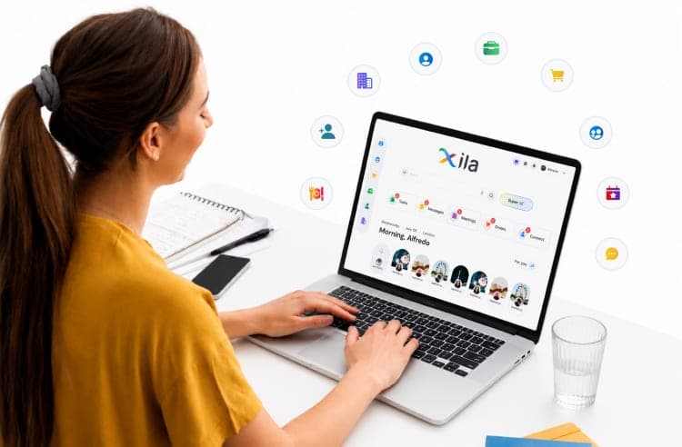 A business owner working in Xila on a laptop, ringed by the app icons Xila replaces